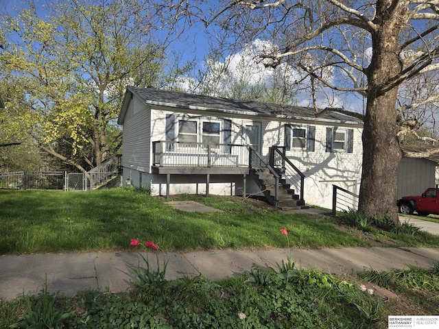 view of front facade featuring stairs, fence, a front yard, and a deck