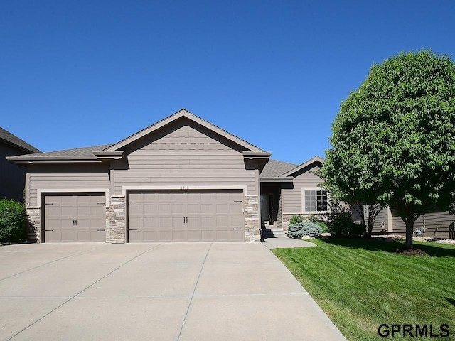 ranch-style home with an attached garage, a front lawn, stone siding, and driveway