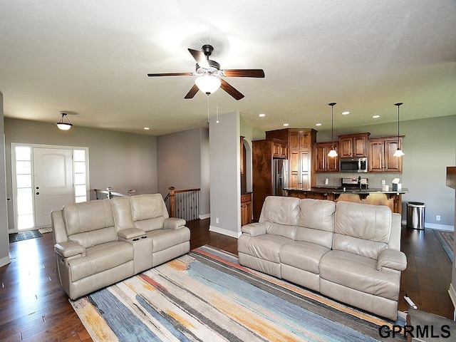 living room featuring baseboards, dark wood-style flooring, a ceiling fan, and recessed lighting