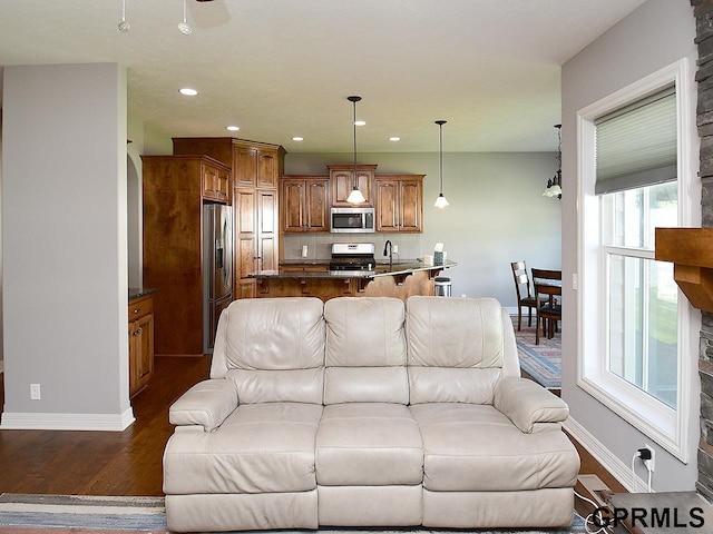 living area with dark wood-style flooring, baseboards, and recessed lighting