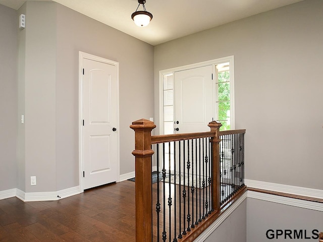 foyer entrance featuring dark wood-type flooring and baseboards