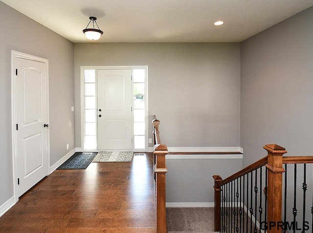 foyer with dark wood-style flooring, baseboards, and recessed lighting