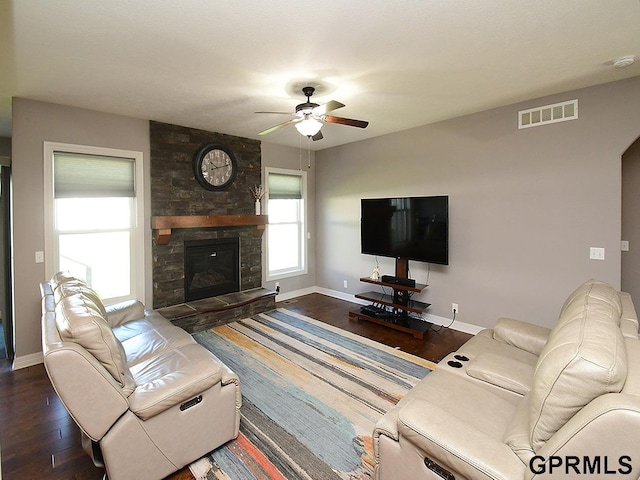 living area with wood finished floors, ceiling fan, baseboards, and a fireplace