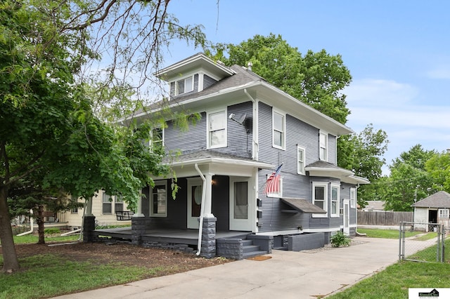 3218 Holdrege St, Lincoln, NE 68503 - american foursquare style home with a porch, a shingled roof, and a gate