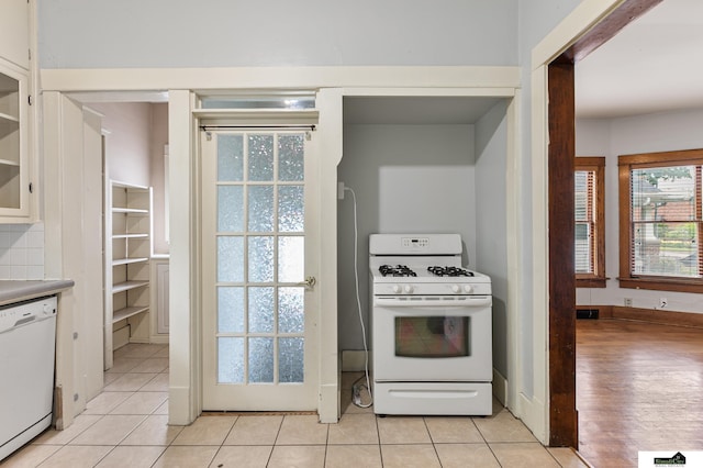 3218 Holdrege St, Lincoln, NE 68503 - kitchen with white appliances, white cabinetry, and light tile patterned flooring