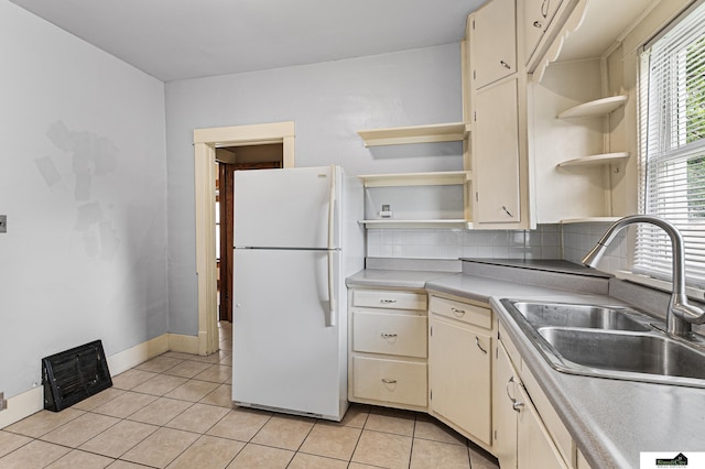 3218 Holdrege St, Lincoln, NE 68503 - kitchen with freestanding refrigerator, open shelves, cream cabinetry, a sink, and light tile patterned flooring