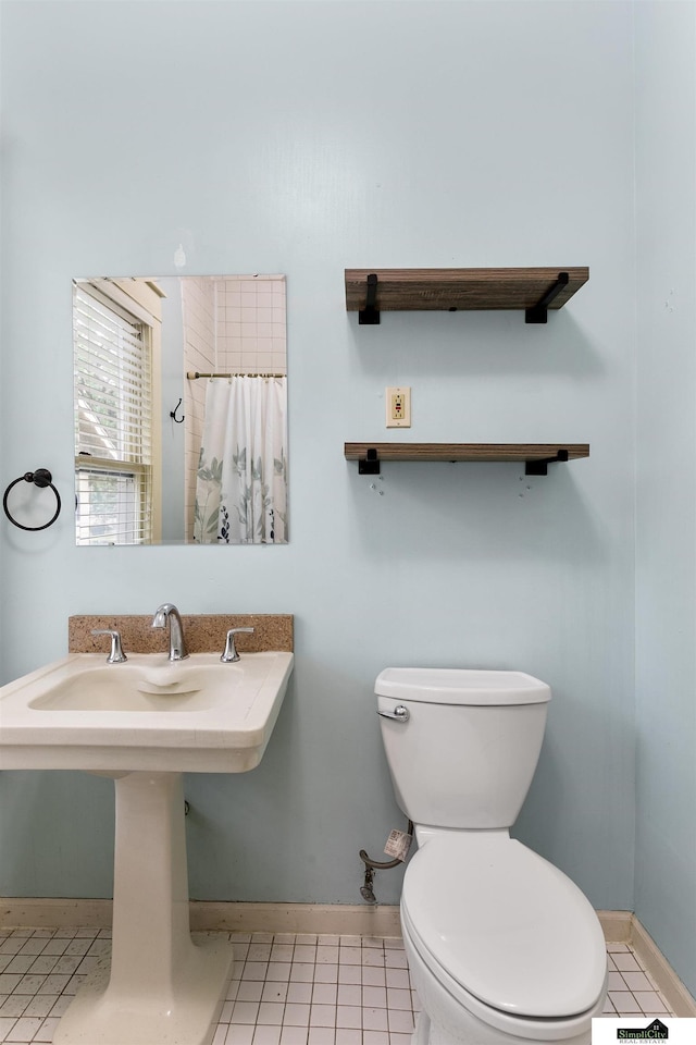 3218 Holdrege St, Lincoln, NE 68503 - bathroom featuring baseboards, toilet, and a shower with shower curtain