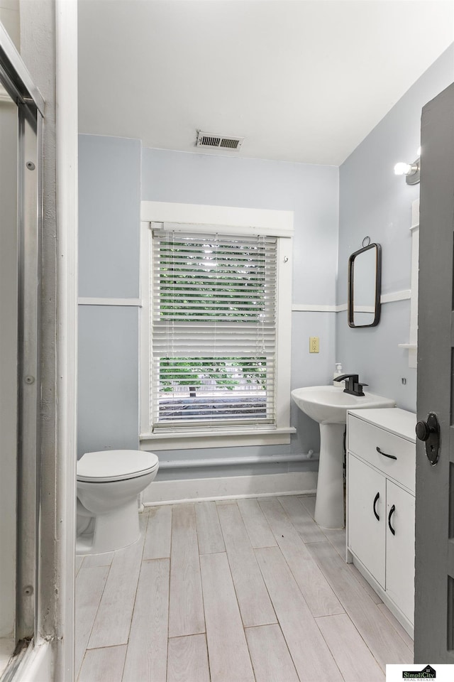 3218 Holdrege St, Lincoln, NE 68503 - full bath with wood finished floors, toilet, and an enclosed shower