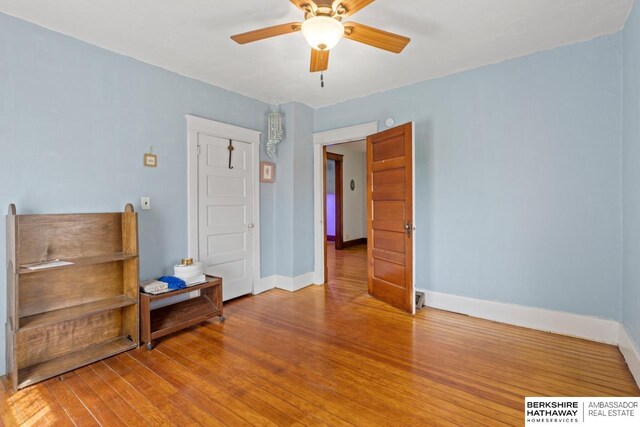6301 SW 34th Ct, Lincoln, NE 68523 - bedroom featuring baseboards, a ceiling fan, and wood finished floors