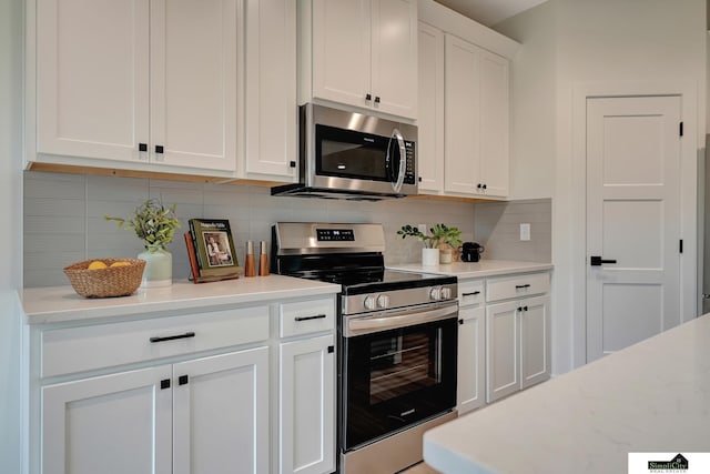 kitchen featuring light countertops, white cabinetry, appliances with stainless steel finishes, and decorative backsplash