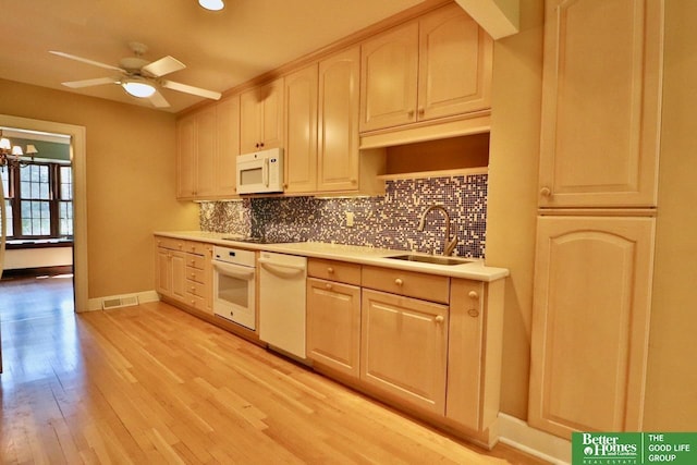 5506 Howard St, Omaha, NE 68106 - kitchen with white appliances, a sink, tasteful backsplash, light countertops, and a ceiling fan