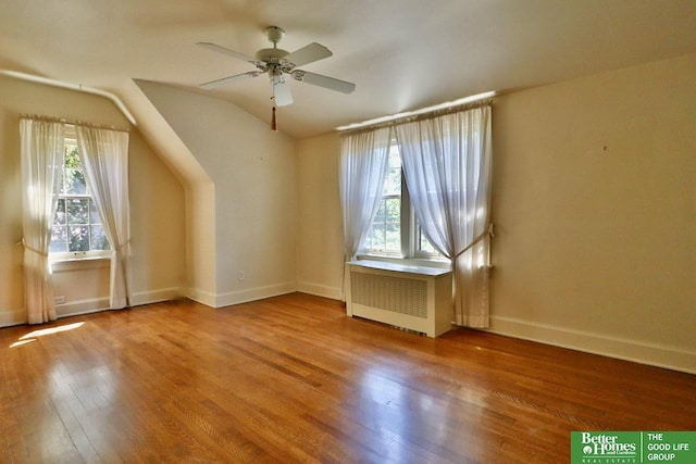 5506 Howard St, Omaha, NE 68106 - bonus room featuring radiator, hardwood / wood-style floors, a ceiling fan, vaulted ceiling, and baseboards