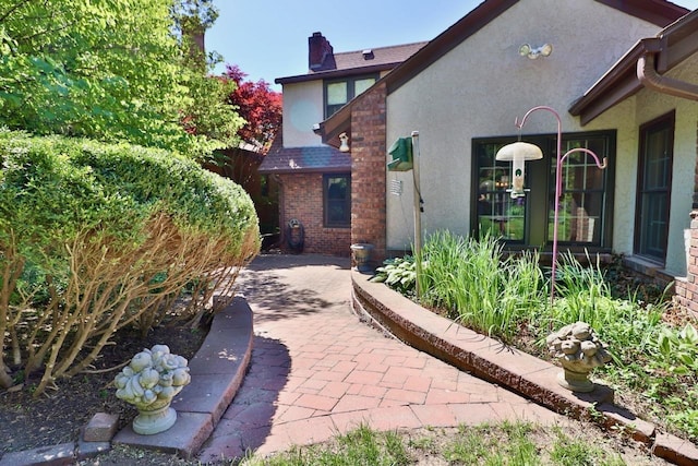 5506 Howard St, Omaha, NE 68106 - view of side of property featuring stucco siding and a chimney