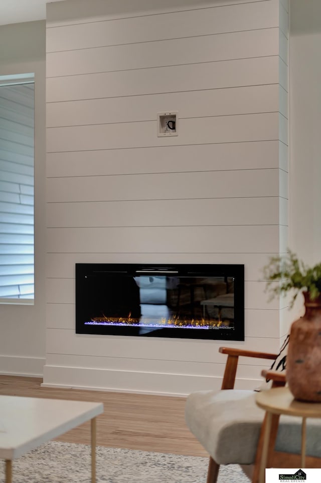 details with baseboards, wood finished floors, and a fireplace
