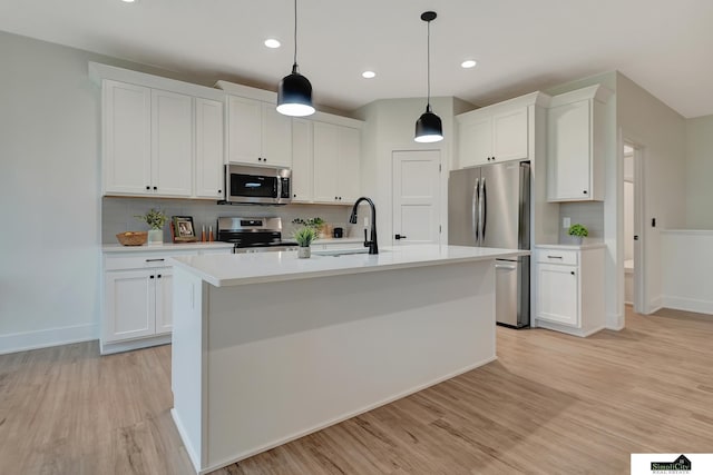 kitchen with light wood-type flooring, a sink, light countertops, stainless steel appliances, and white cabinetry