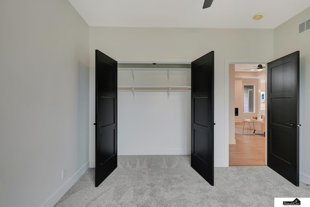 unfurnished bedroom with carpet flooring, ceiling fan, baseboards, visible vents, and a closet