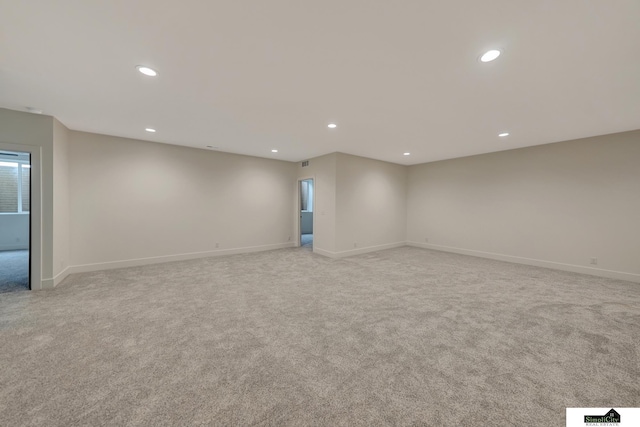 spare room featuring recessed lighting, baseboards, and light carpet