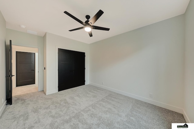 unfurnished bedroom with a ceiling fan, baseboards, light colored carpet, and a closet