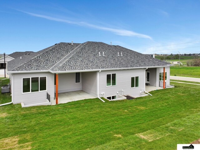rear view of house featuring a lawn, cooling unit, and a patio area