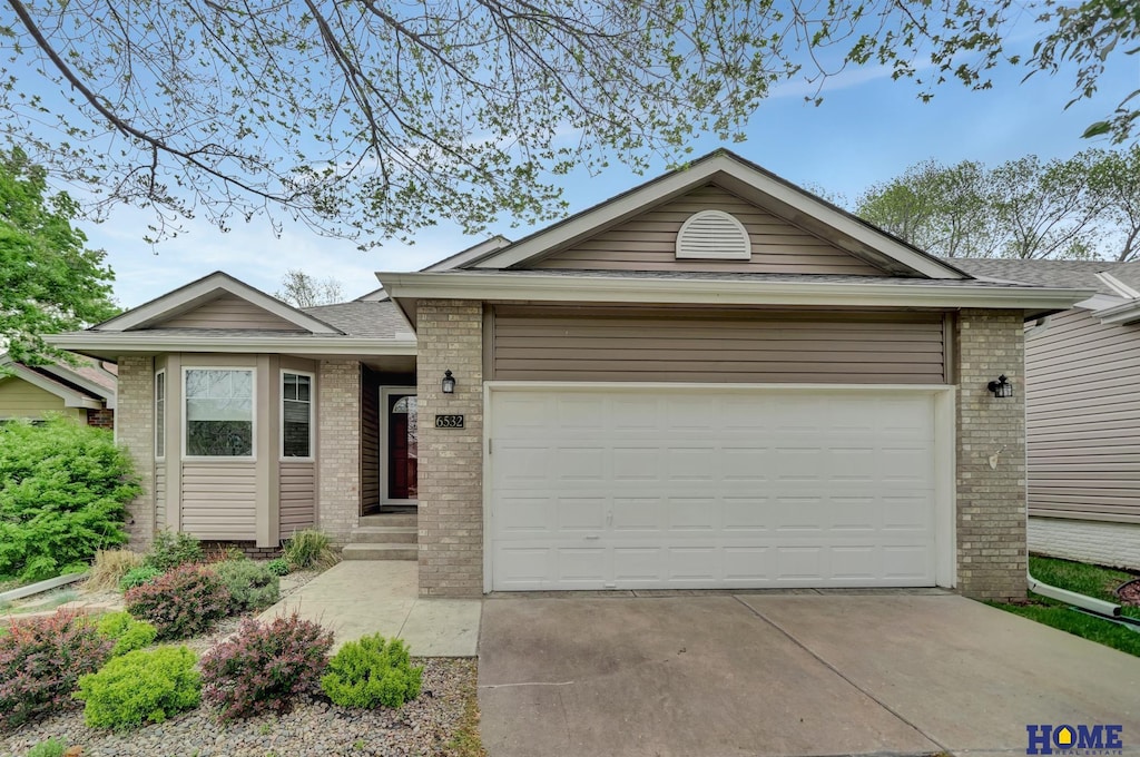 single story home with brick siding, a garage, roof with shingles, and driveway