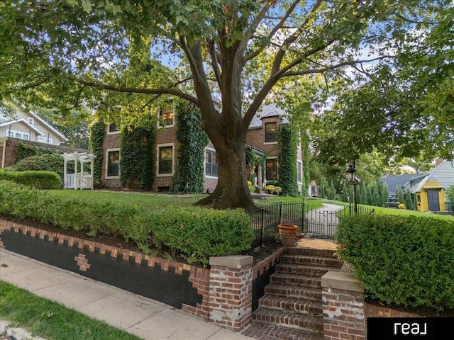 obstructed view of property with a front yard, brick siding, and fence