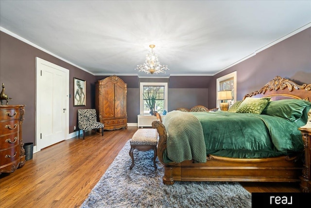 bedroom featuring ornamental molding, a notable chandelier, baseboards, and wood finished floors