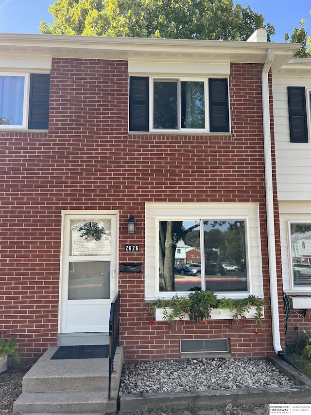 townhome / multi-family property with brick siding and a chimney