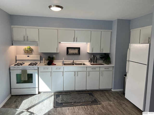 kitchen featuring white appliances, under cabinet range hood, a sink, and dark wood finished floors