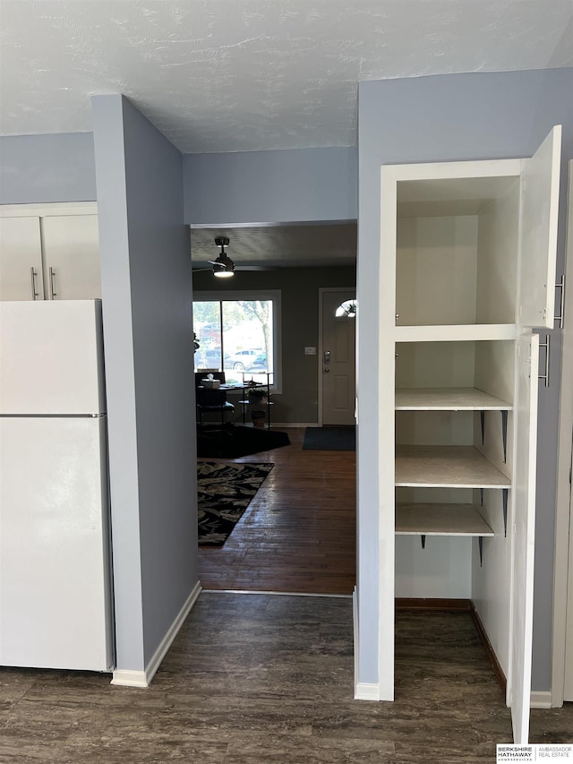 hallway with baseboards and wood finished floors