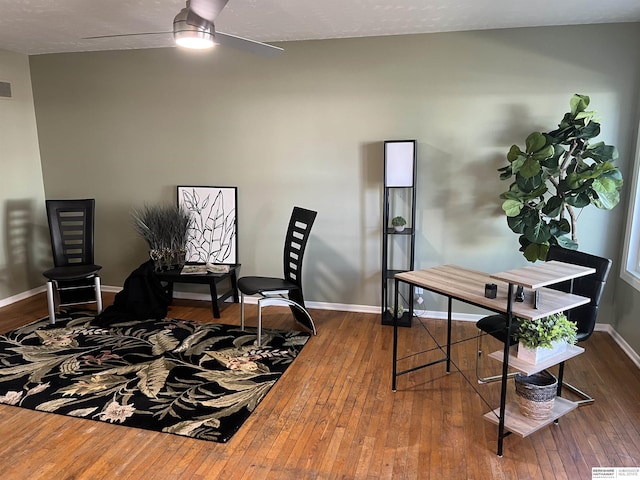 office area featuring a ceiling fan, baseboards, visible vents, and hardwood / wood-style flooring
