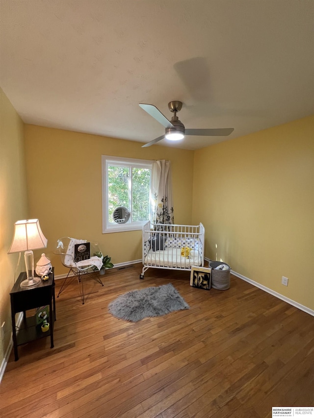bedroom featuring baseboards, a ceiling fan, and hardwood / wood-style flooring