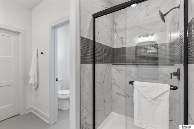 full bath featuring a marble finish shower, toilet, and baseboards