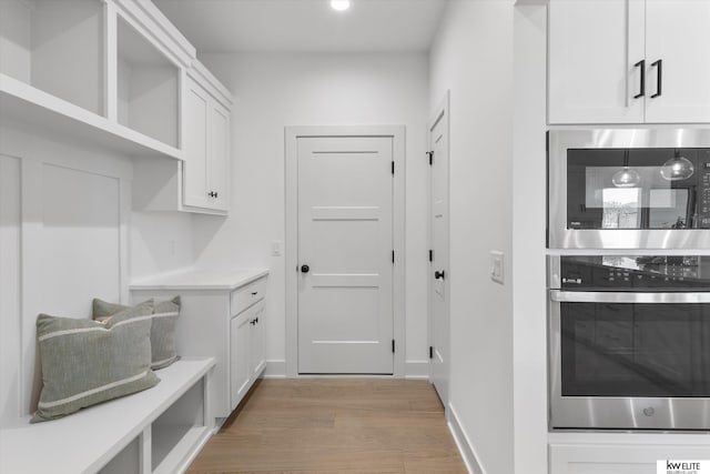 mudroom with light wood-type flooring, baseboards, and recessed lighting