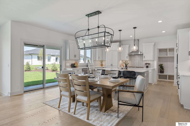 dining space featuring light wood-style flooring, recessed lighting, a chandelier, and baseboards