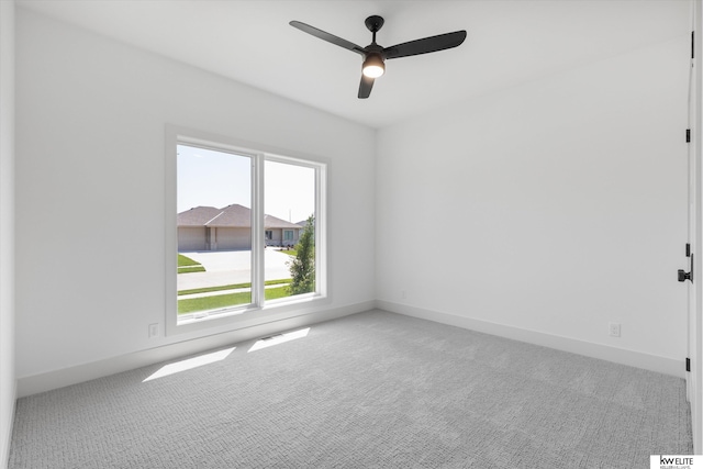 carpeted empty room with ceiling fan and baseboards