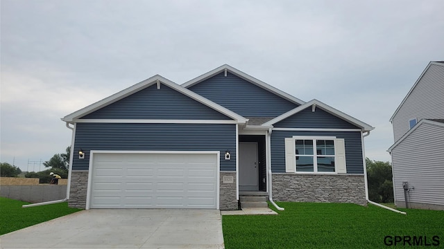 view of front of home featuring an attached garage, driveway, a front lawn, and stone siding