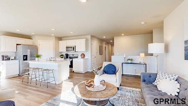 living room with light wood-type flooring and recessed lighting