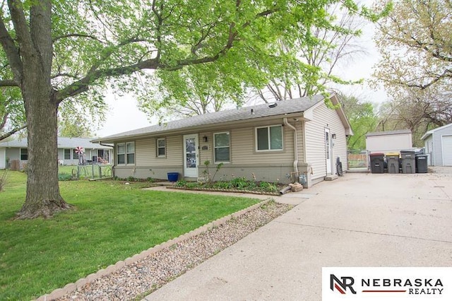 view of front facade with fence, driveway, and a front lawn