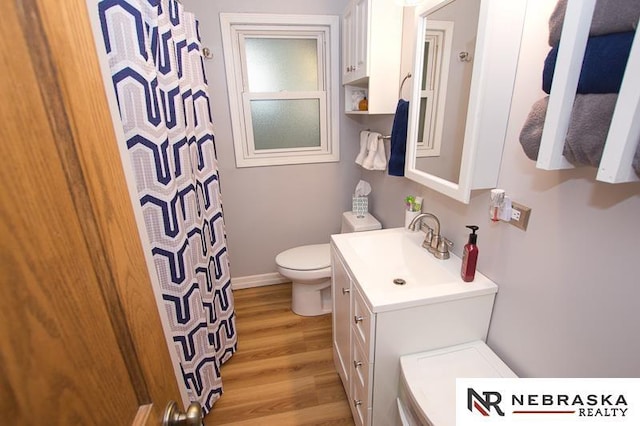 bathroom with a shower with shower curtain, toilet, wood finished floors, and vanity