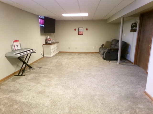 finished basement with baseboards, light colored carpet, and a drop ceiling