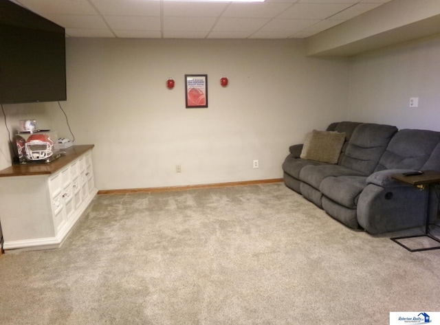 living area with carpet floors, baseboards, and a drop ceiling