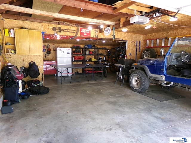 garage featuring a garage door opener and freestanding refrigerator