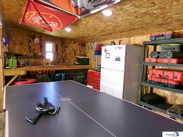 playroom featuring wooden walls and a workshop area