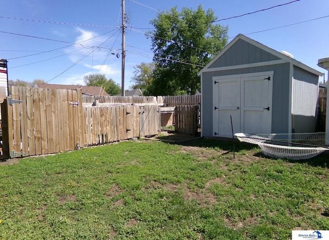 view of yard featuring fence, a storage unit, and an outdoor structure