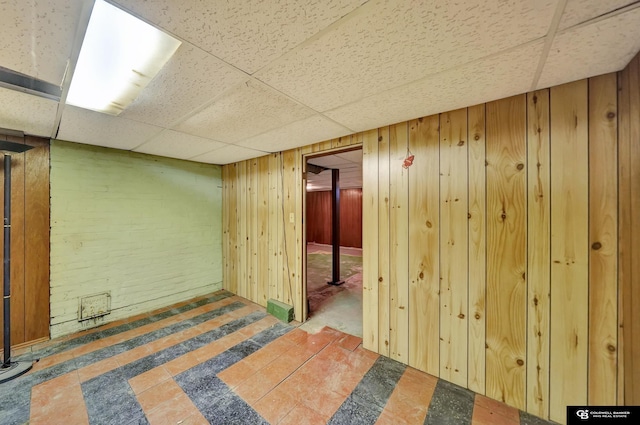 finished below grade area with wood walls and a paneled ceiling
