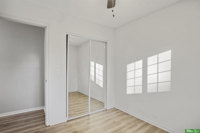 unfurnished bedroom with a closet, baseboards, and wood finished floors