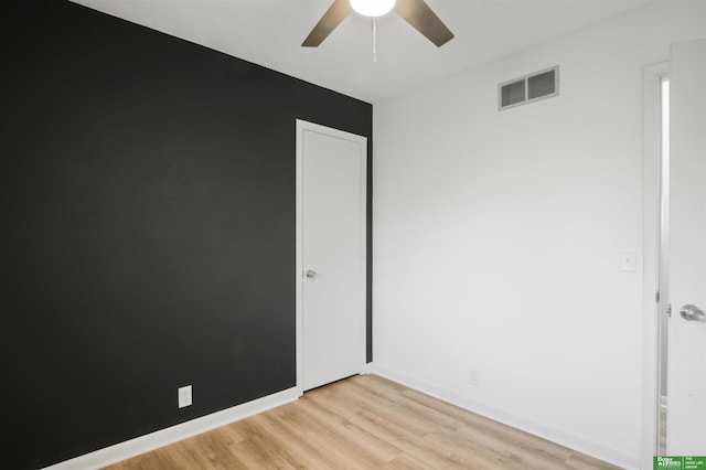 empty room featuring ceiling fan, visible vents, and light wood-style flooring