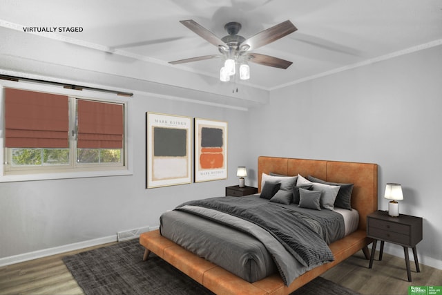 bedroom featuring crown molding, ceiling fan, baseboards, wood finished floors, and visible vents