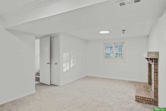 basement featuring visible vents, carpet, baseboards, and a fireplace