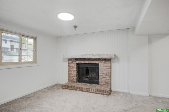 unfurnished living room with baseboards, carpet, and a brick fireplace